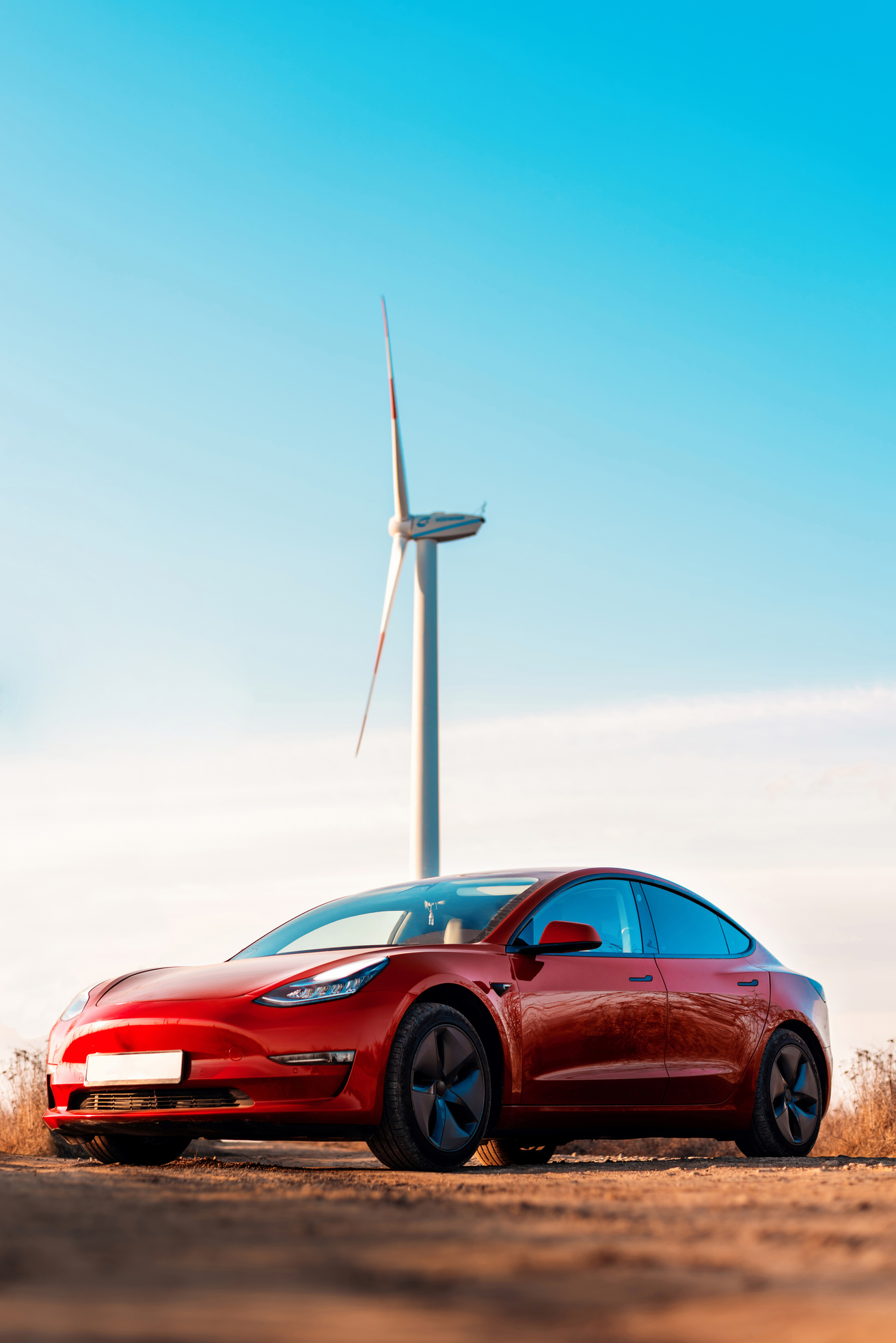 Parked red Tesla Model 3 at sunset